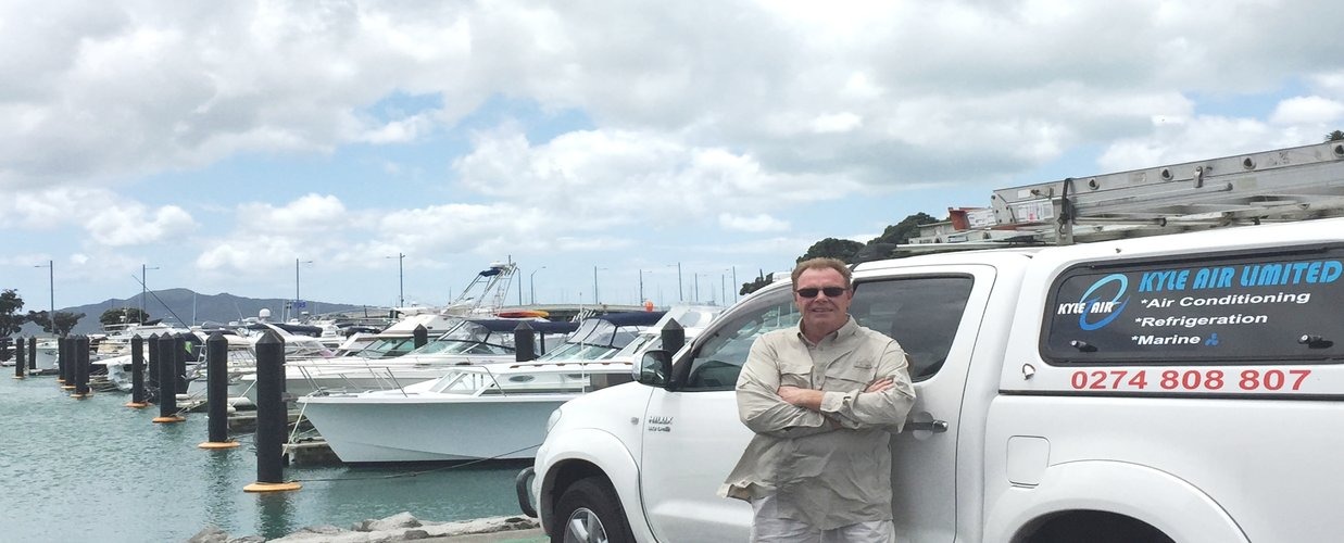 Jon Kyle, air conditioning and refrigeration engineer with Kyle Air work truck at marina